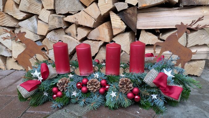 Adventskranz lang mit roten Kerzen Hirschen aus Metall Rost Schleifen aus Jute Natur und Zapfen und roten Spiegelbeeren